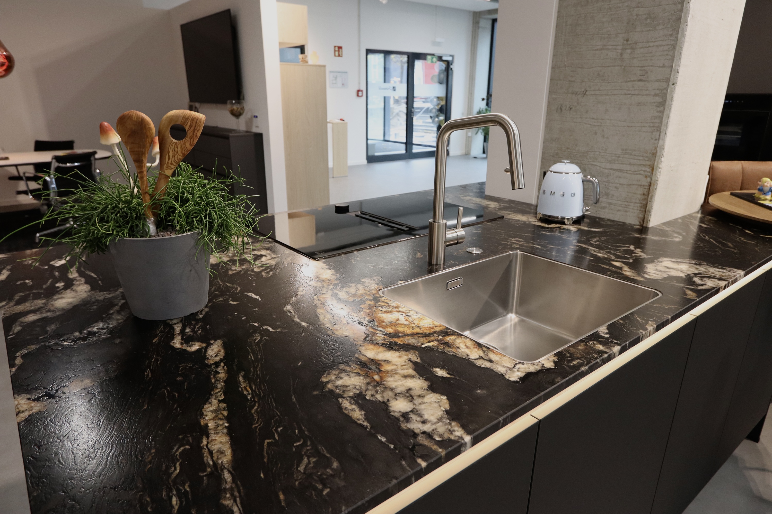 Detailbild der Naturstein-Arbeitsplatte "Black Cosmic" auf einer Häcker Concept Küche von Grünwald Küchen Design in Hohenbrunn